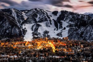 Aspen lit up at night with ski slopes covered in snow