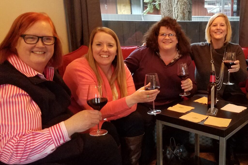 Group of women enjoying a glass of red wine together