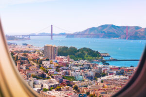 Non-stop flights San Francisco, view of Golden Gate bridge out plane window.