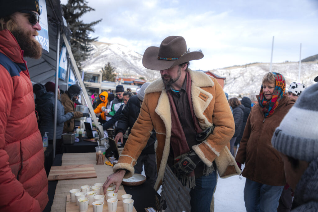 Person in a cowboy hat grabbing soup from Wintersköl Soupsköl event in Aspen
